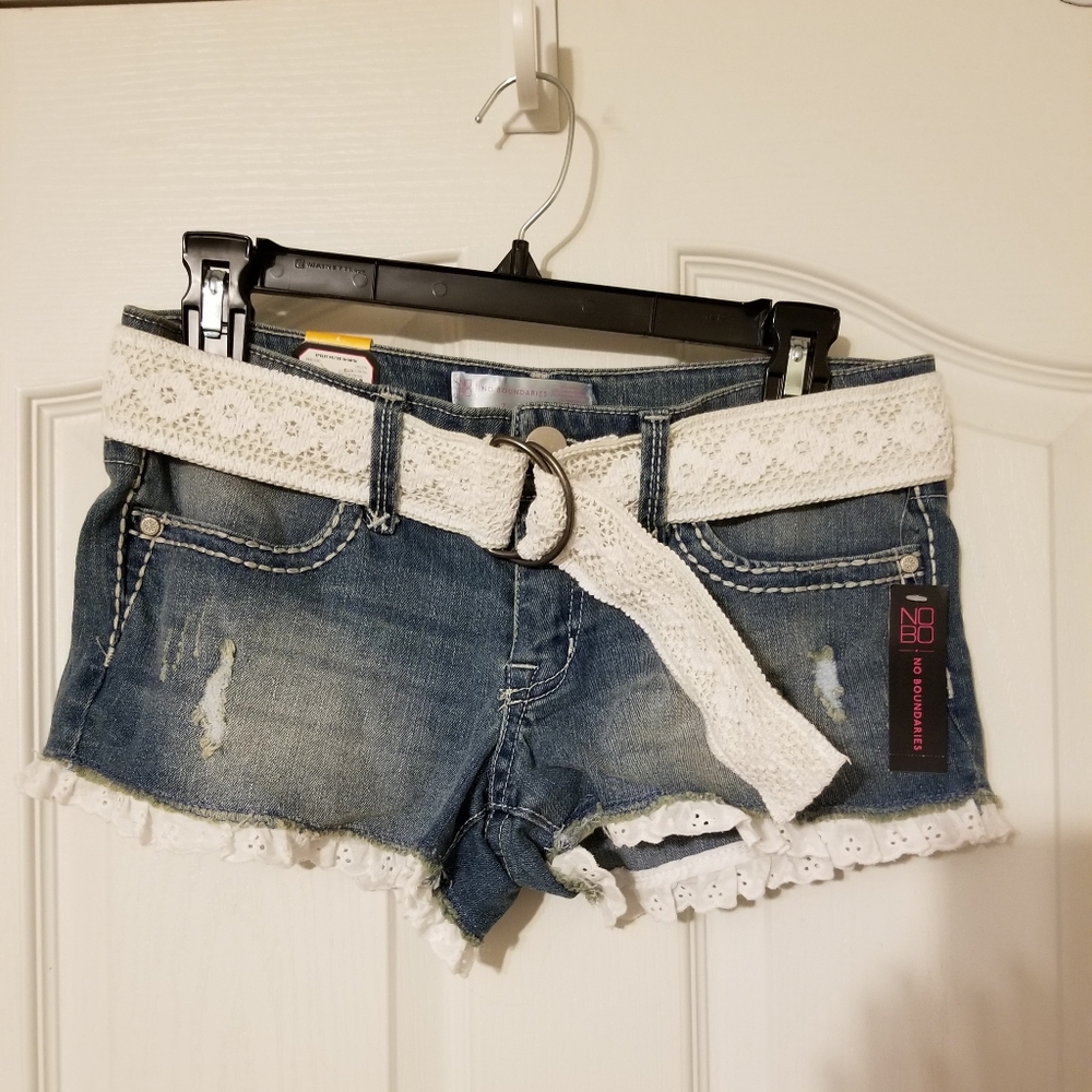 Distressed denim shorts with cotton lace detail.